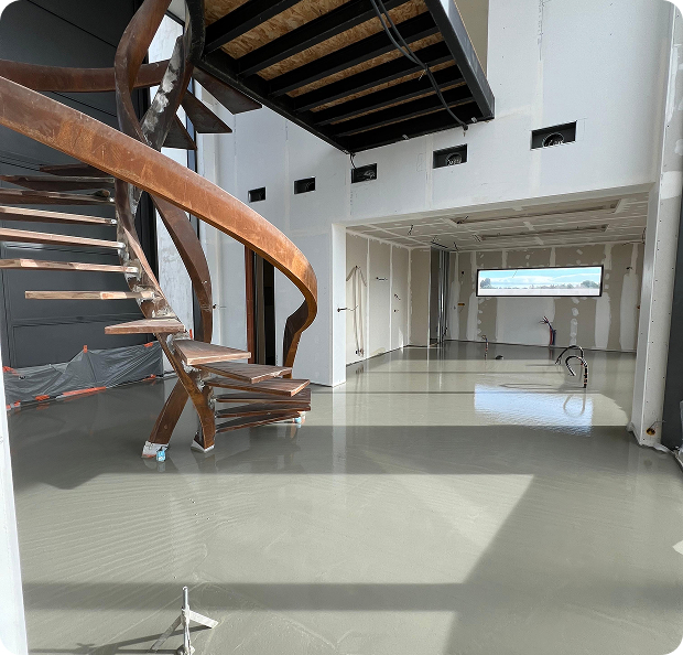 Intérieur de maison moderne en construction avec escalier incurvé et sol brillant à Saint-Nazaire-de-Pezan près de Montpellier dans l'Hérault 34