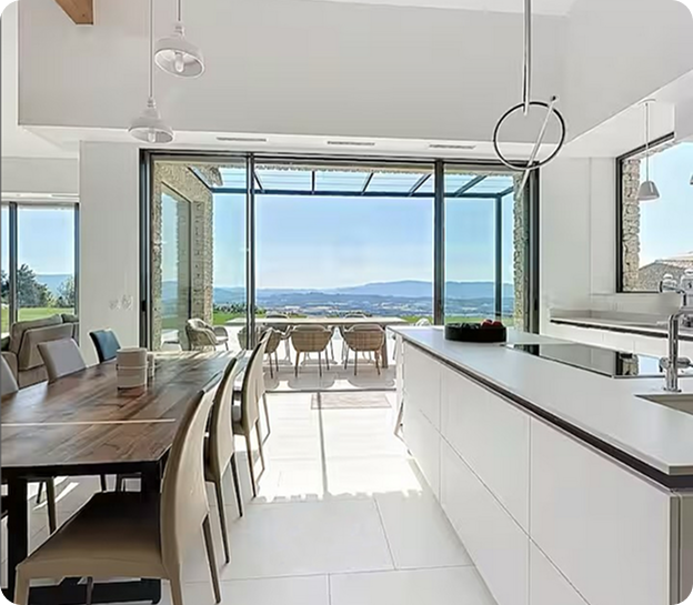 Cuisine moderne et salle à manger avec vue panoramique sur un paysage vallonné à Saint-Nazaire-de-Pezan près de Montpellier dans l'Hérault 34