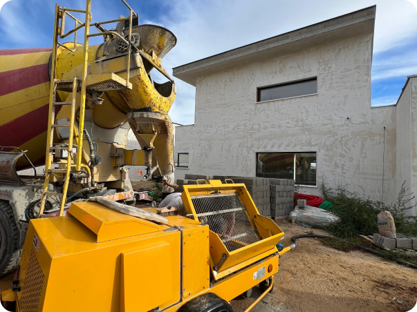 Bétonnière et machine à projeter le béton devant une maison en construction à Saint-Nazaire-de-Pezan près de Montpellier dans l'Hérault 34