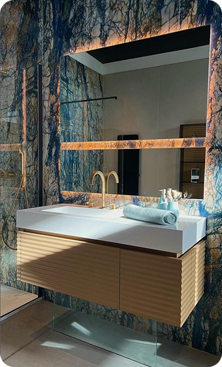 Salle de bain moderne avec mur texturé, miroir éclairé et lavabo flottant en bois à Saint-Nazaire-de-Pezan près de Montpellier dans l'Hérault 34