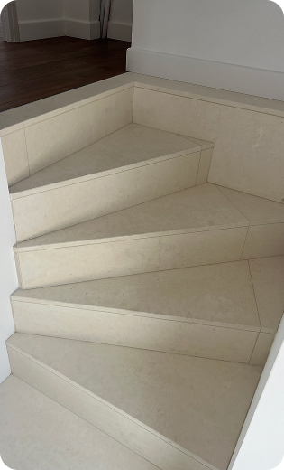 Escalier tournant en pierre claire, carrelé, menant à un plancher en bois foncé à Saint-Nazaire-de-Pezan près de Montpellier dans l'Hérault 34