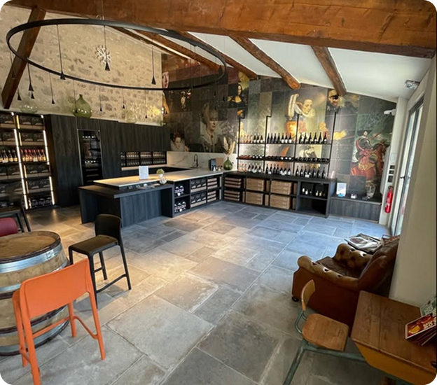 Intérieur de cave à vin moderne avec poutres apparentes, murs décorés et dégustation à Saint-Nazaire-de-Pezan près de Montpellier dans l'Hérault 34