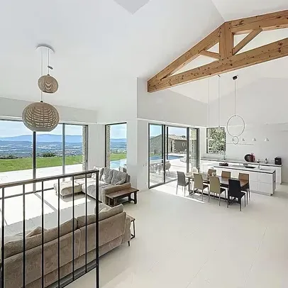 Grand salon/cuisine moderne avec de grandes baies vitrées offrant une vue sur la campagne à Saint-Nazaire-de-Pezan près de Montpellier dans l'Hérault 34