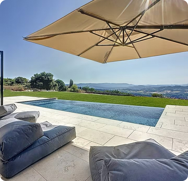 Piscine à débordement avec vue panoramique sur la campagne, chaises longues et parasol à Saint Nazaire de Pézan près de Montpellier dans l'Hérault 34